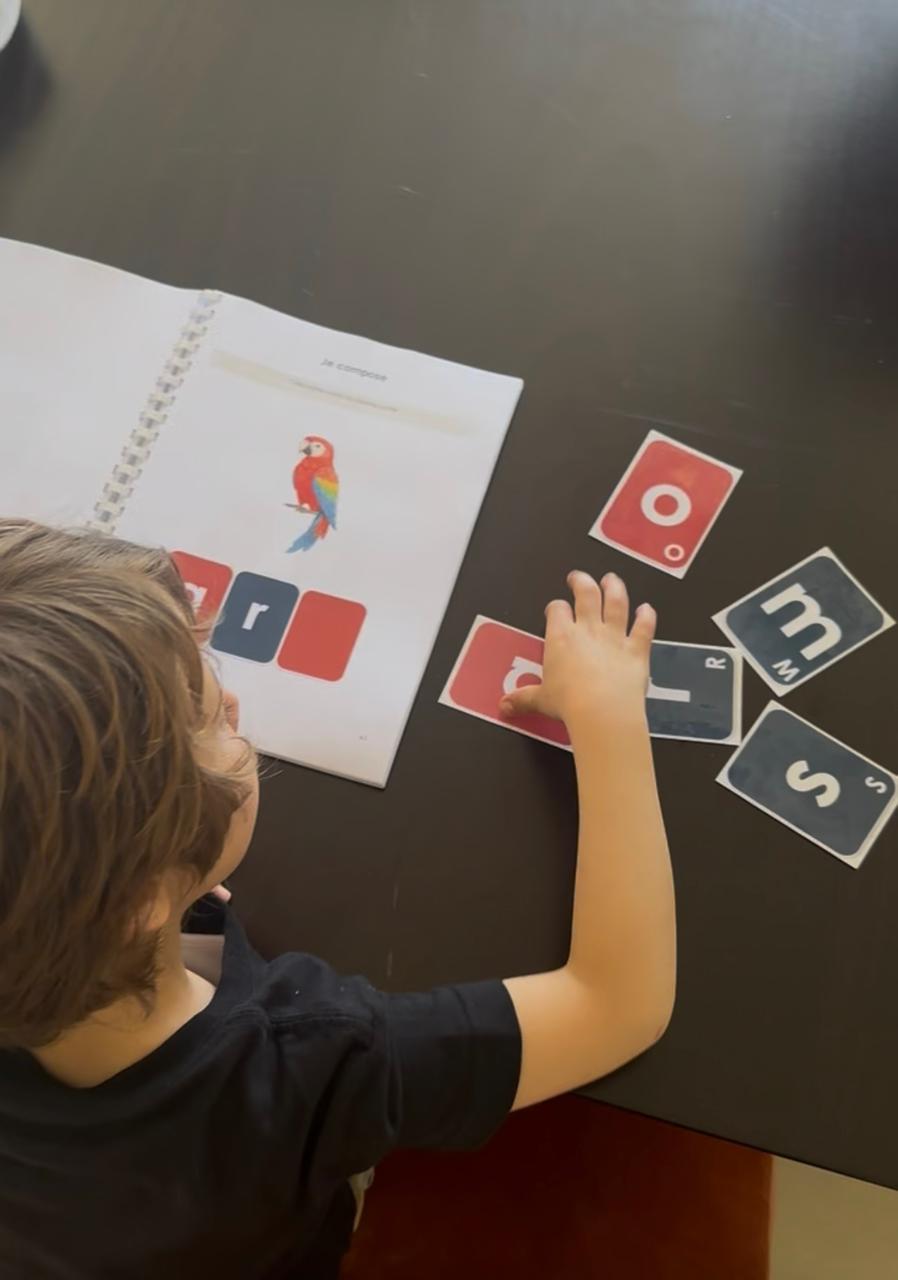 Enfant utilisant les cartes lettres Lire C'est Facile