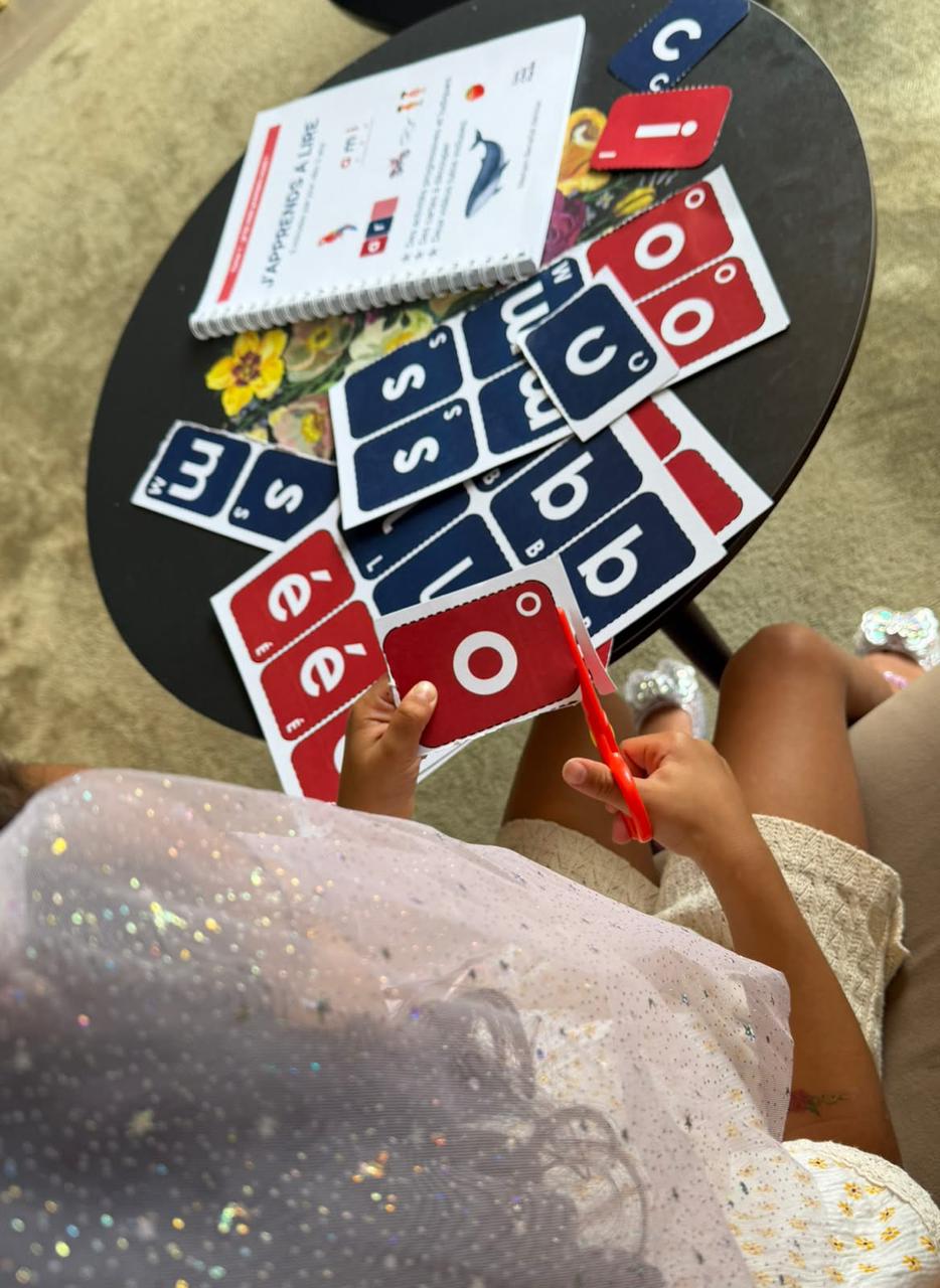 Enfant découpant ses cartes lettres