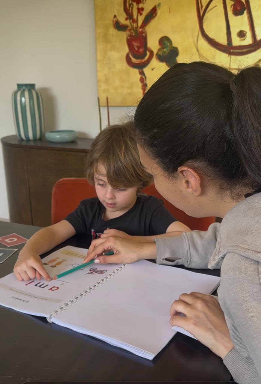 Maman accompagnant son enfant avec le cahier Lire C'est Facile